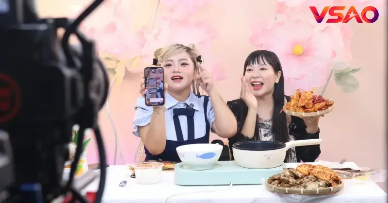 Hình ảnh ghi lại một phiên livestream đánh giá quán ăn trực tiếp tại không gian bếp mở của nhà hàng.